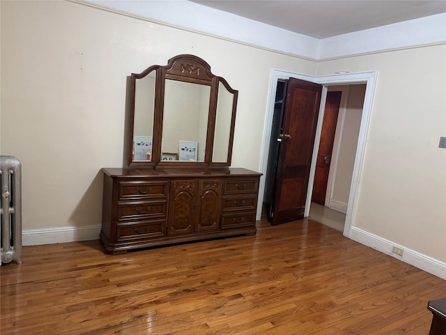 bedroom with radiator and wood-type flooring