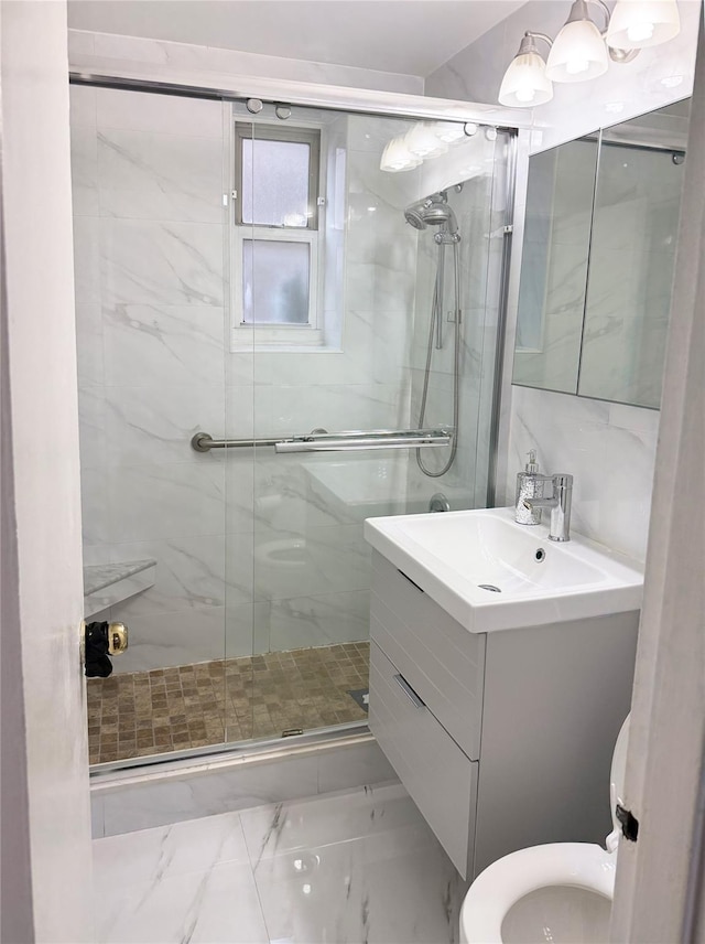 bathroom featuring a shower with door, toilet, and vanity