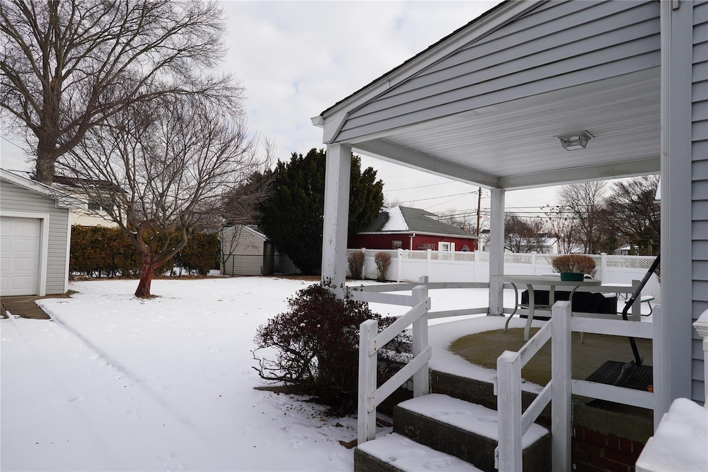 yard covered in snow featuring a storage unit