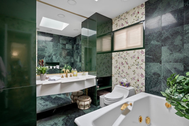 bathroom featuring a tub, toilet, a skylight, and tile walls