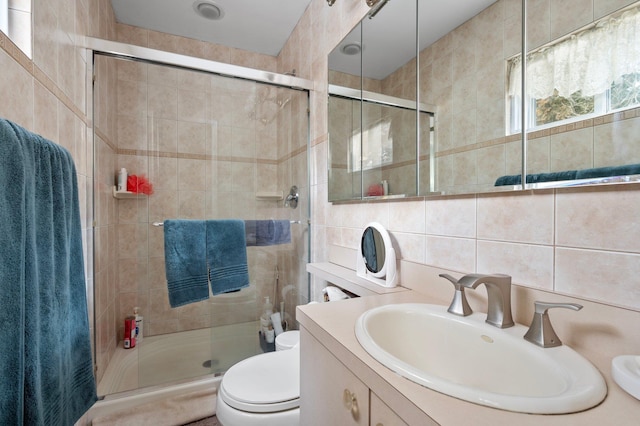 bathroom featuring vanity, backsplash, toilet, walk in shower, and tile walls