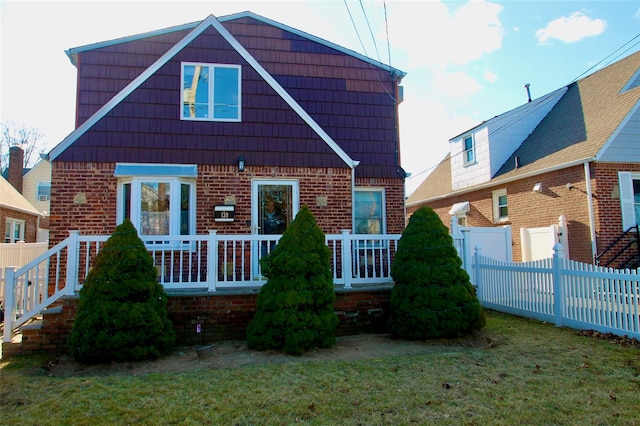 rear view of house with a wooden deck and a yard