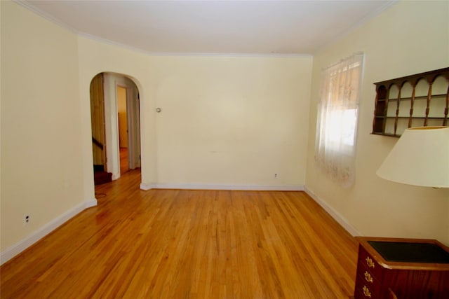 spare room featuring crown molding and light hardwood / wood-style floors