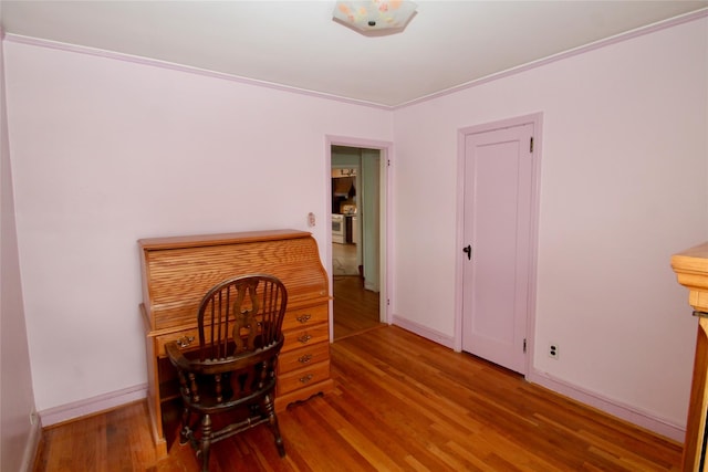 home office with crown molding and light hardwood / wood-style flooring