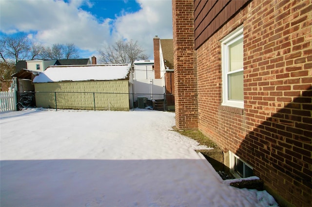 snow covered property with central AC unit