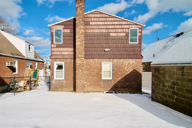 view of snow covered back of property