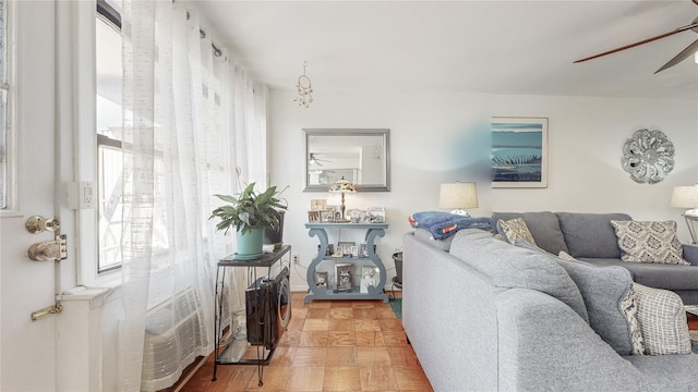 living room featuring ceiling fan and parquet flooring