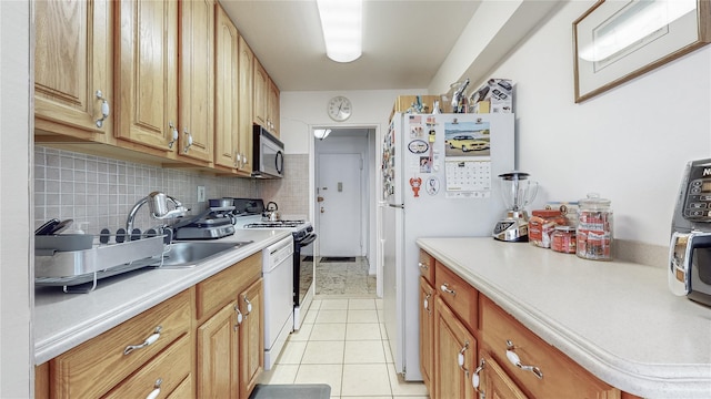 kitchen featuring range, light tile patterned floors, decorative backsplash, sink, and white refrigerator