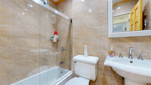 full bathroom featuring sink, toilet, combined bath / shower with glass door, and backsplash