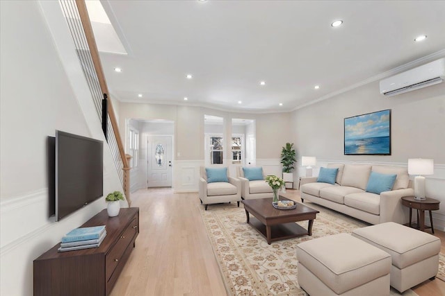 living room featuring a wall mounted air conditioner, ornamental molding, and light hardwood / wood-style floors