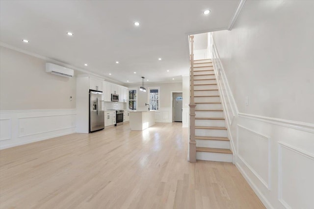 unfurnished living room featuring crown molding, a wall mounted air conditioner, and light hardwood / wood-style flooring