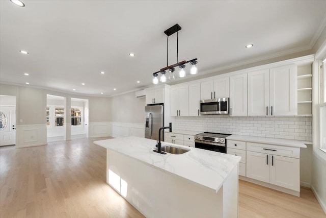 kitchen featuring white cabinets, decorative light fixtures, appliances with stainless steel finishes, and sink