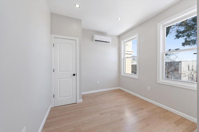 spare room with light hardwood / wood-style floors and a wall mounted air conditioner