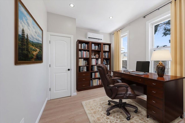 office with light hardwood / wood-style floors and a wall unit AC