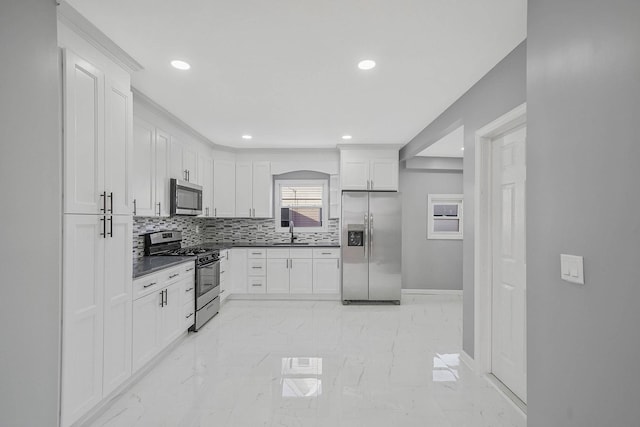 kitchen with sink, white cabinetry, stainless steel appliances, and tasteful backsplash