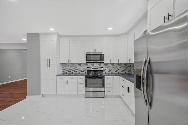 kitchen featuring decorative backsplash, white cabinets, and stainless steel appliances