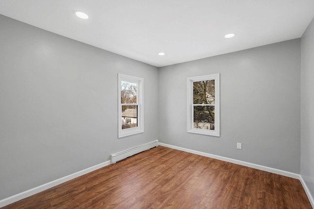 spare room with hardwood / wood-style flooring and a baseboard radiator