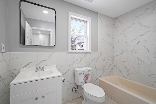 full bathroom featuring toilet, tile walls, tile patterned floors, vanity, and washtub / shower combination