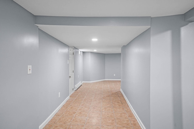 basement with light tile patterned flooring and a baseboard heating unit