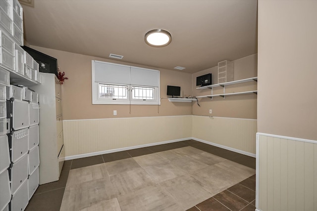 walk in closet with dark tile patterned floors