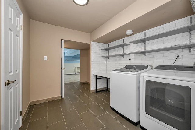 clothes washing area featuring washer and clothes dryer and dark tile patterned floors