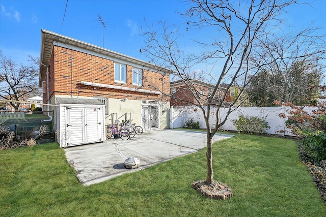 back of property with a patio area, a lawn, and a storage unit