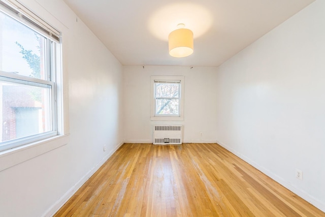 spare room featuring light hardwood / wood-style floors and radiator heating unit