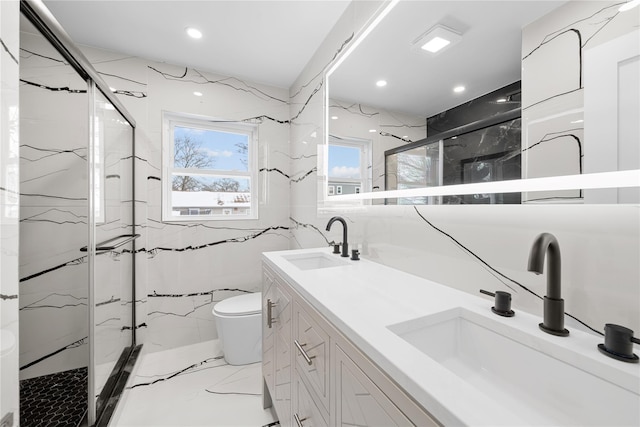 bathroom featuring toilet, a shower with shower door, and vanity