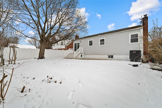 snow covered back of property with central air condition unit