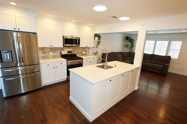 kitchen with sink, white cabinetry, stainless steel appliances, and tasteful backsplash