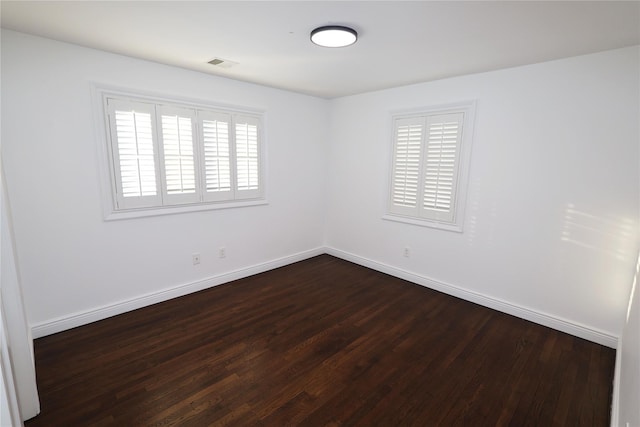 unfurnished room featuring dark wood-type flooring and plenty of natural light