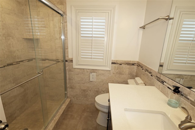 bathroom featuring vanity, toilet, walk in shower, and tile patterned flooring