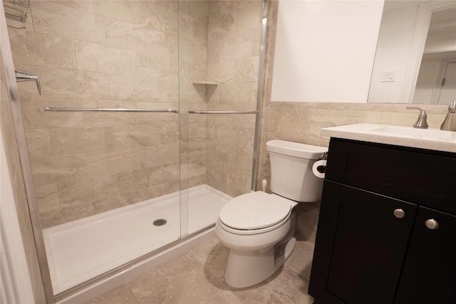 bathroom with vanity, toilet, tile walls, and a shower with door