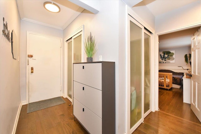 corridor with hardwood / wood-style flooring and ornamental molding