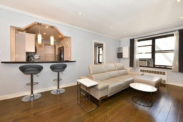 living room with radiator heating unit, sink, cooling unit, dark hardwood / wood-style flooring, and ornamental molding