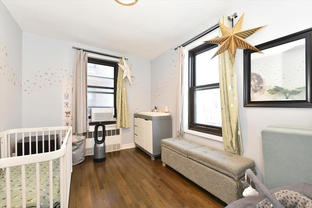 bedroom with dark wood-type flooring, radiator, multiple windows, and cooling unit