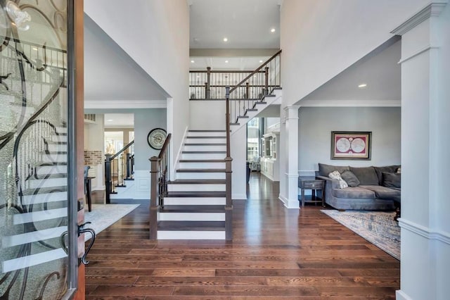 entryway with ornamental molding, dark hardwood / wood-style flooring, and ornate columns