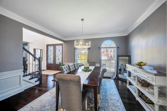 dining room with crown molding, dark hardwood / wood-style floors, french doors, and a notable chandelier