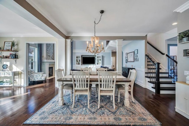 dining space with an inviting chandelier, dark wood-type flooring, ornamental molding, and decorative columns