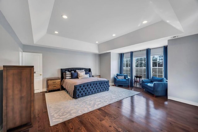 bedroom featuring dark hardwood / wood-style floors and a raised ceiling