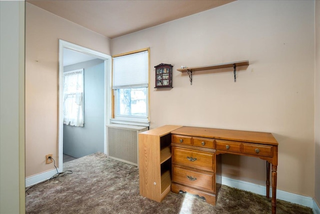 home office with radiator heating unit and dark colored carpet