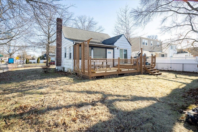 back of property with a yard and a deck