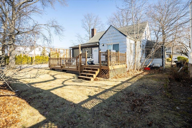 rear view of house with a wooden deck and a yard