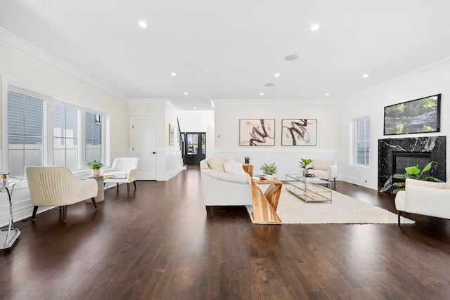 living room featuring a premium fireplace, ornamental molding, and dark wood-type flooring