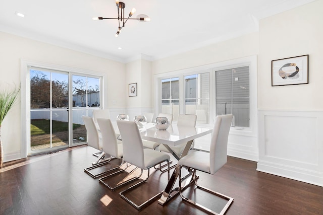 dining room featuring crown molding, dark wood-type flooring, and a notable chandelier