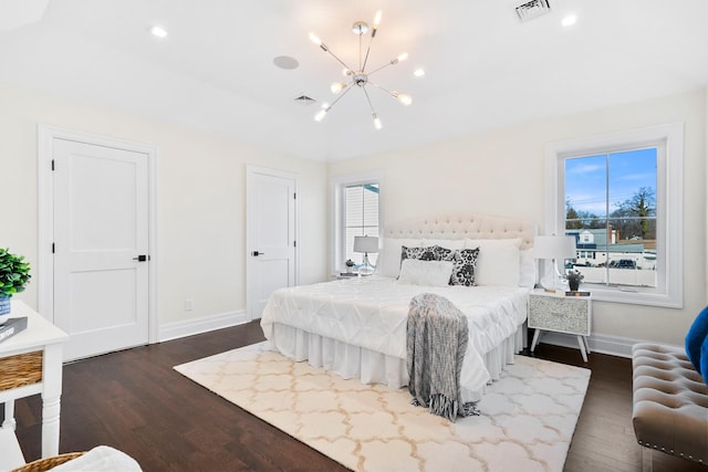 bedroom featuring a notable chandelier and dark hardwood / wood-style flooring