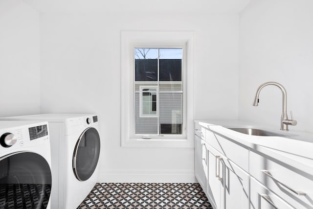 washroom featuring cabinets, sink, and washer and clothes dryer