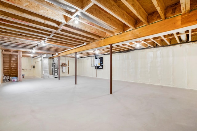 basement featuring electric panel and heating unit