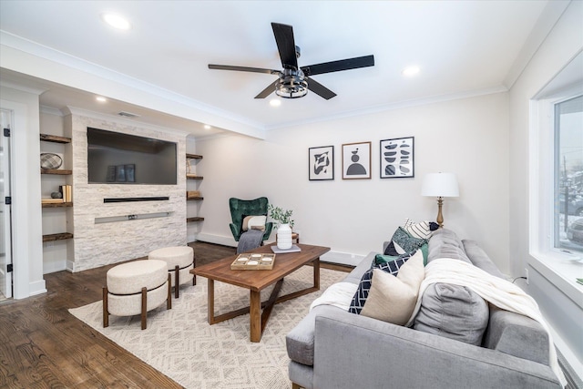 living room with crown molding, hardwood / wood-style floors, built in features, and ceiling fan