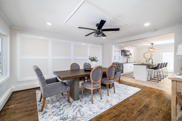 dining area with hardwood / wood-style flooring, ceiling fan, crown molding, and a baseboard radiator